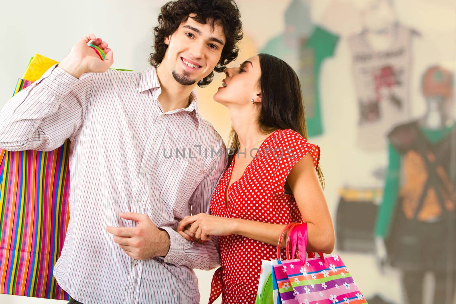 Photo of young woman whispering something to her boyfriend in the trade center