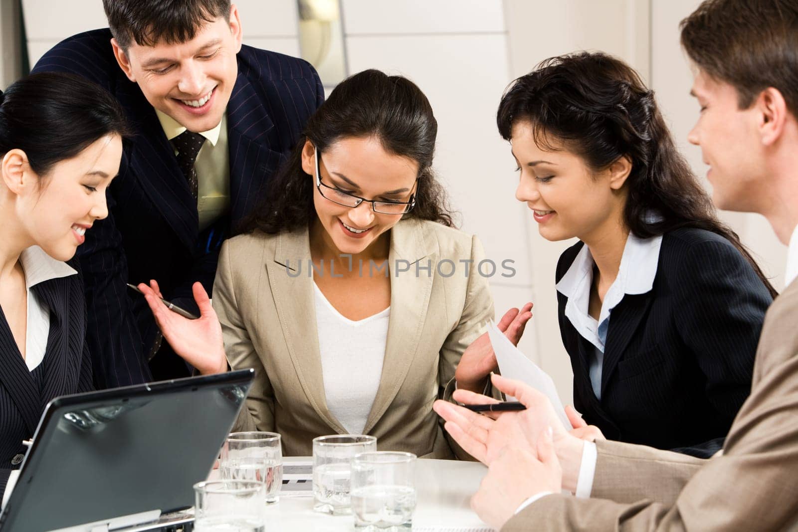 Image of successful businesswoman with four colleagues looking at plan near by