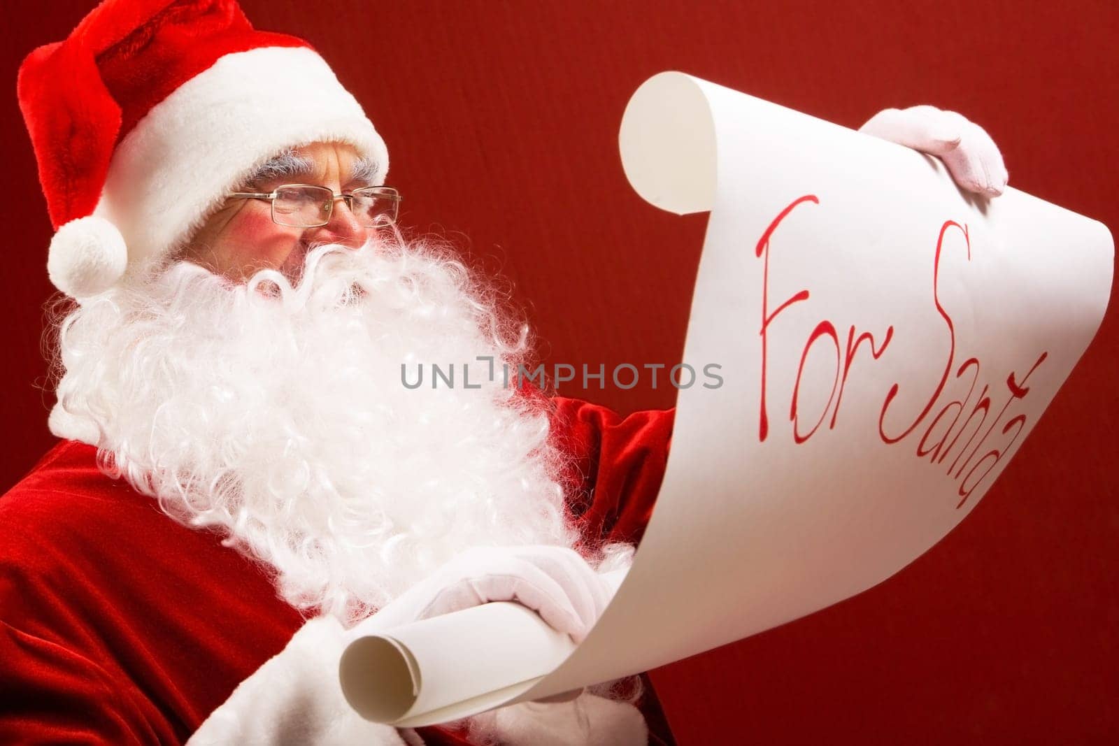 Portrait of Santa Claus reading big letter attentively