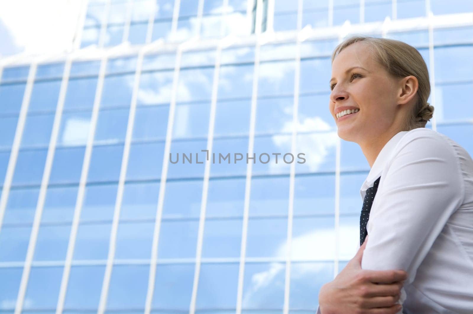 Image of pretty businesswoman looking forwards on background of modern building outdoors
