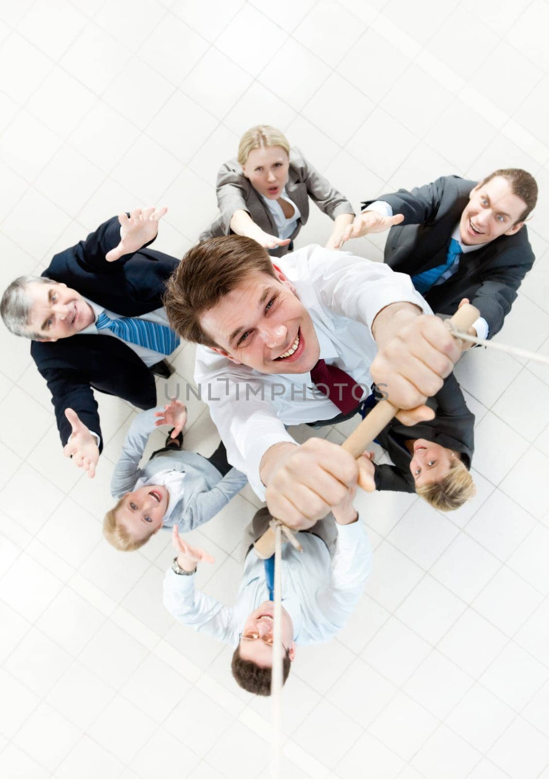 Above view of businessman holding plank on ropes and hanging on it with supporting crew beneath