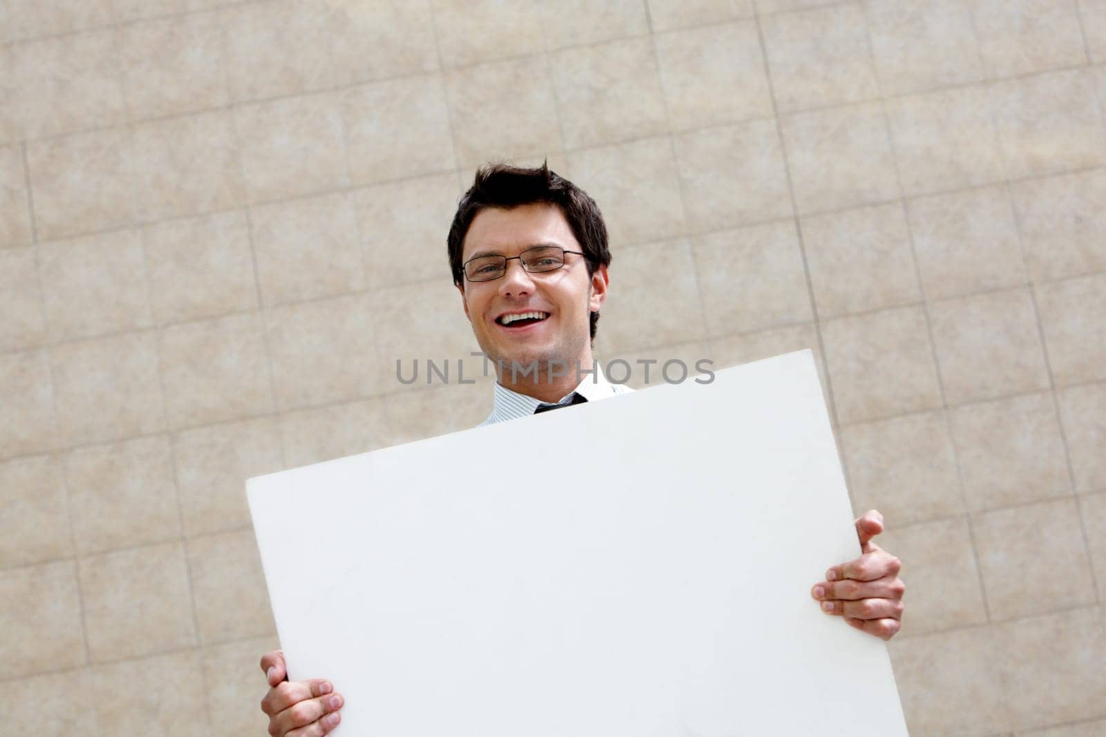 Image of successful male with blank paper looking at camera and smiling