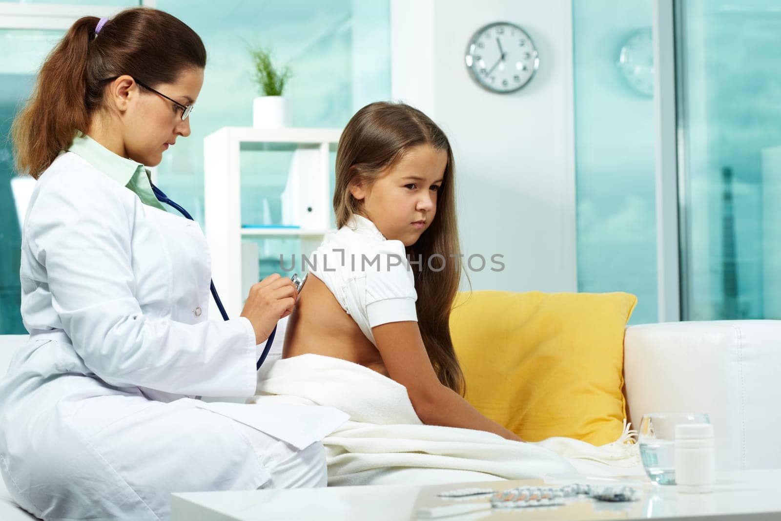 Portrait of serious clinician treating sick girl with stethoscope