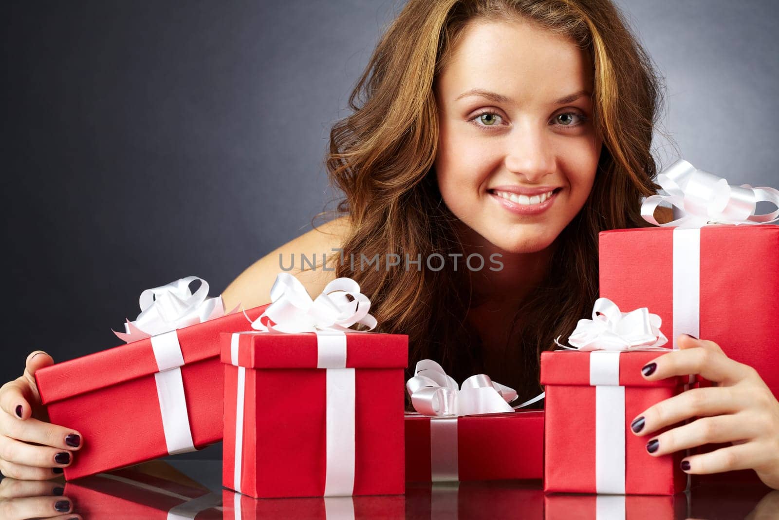 Portrait of a girl with giftboxes looking at camera and smiling