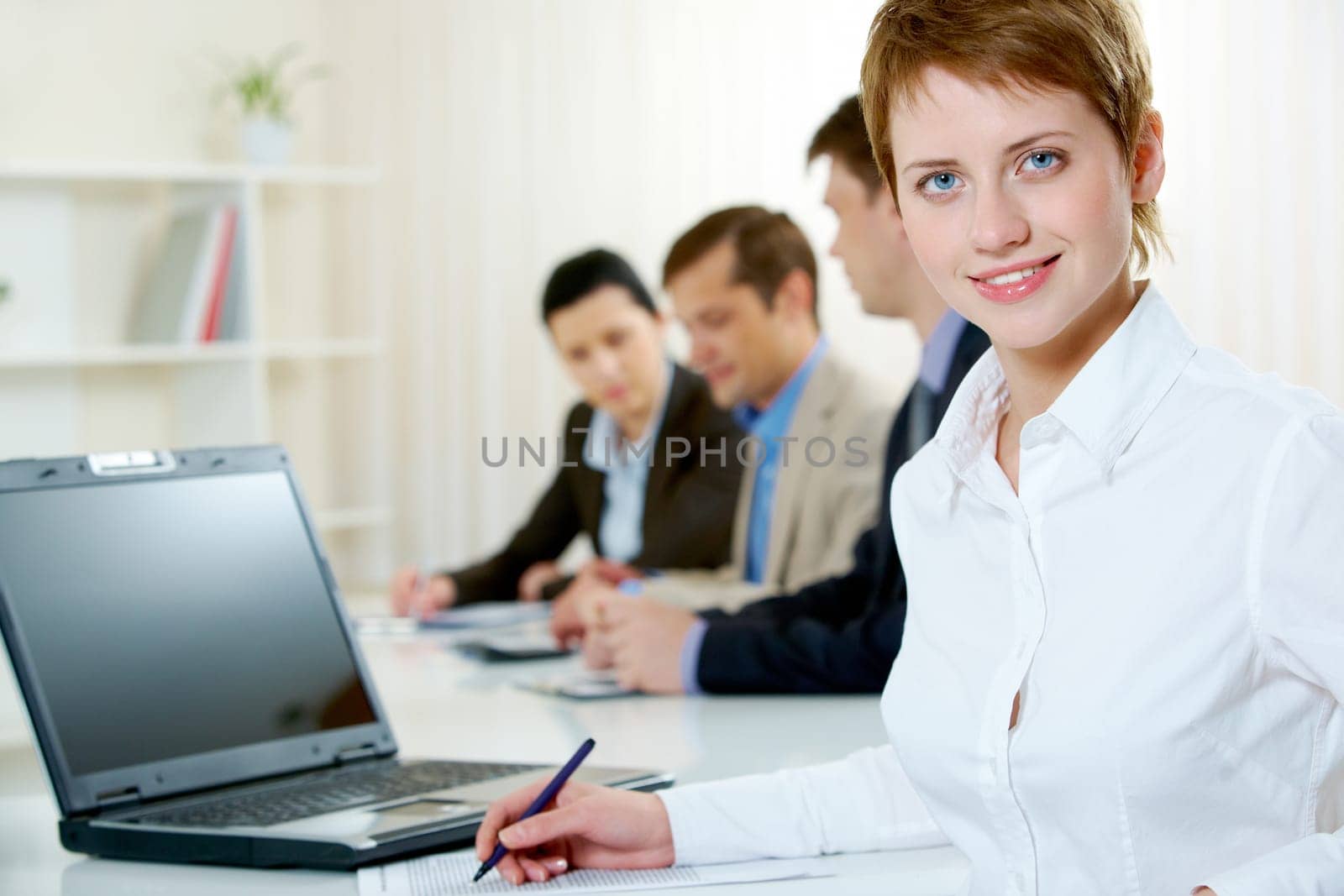 Image of pretty blue-eyed female looking at camera in working environment