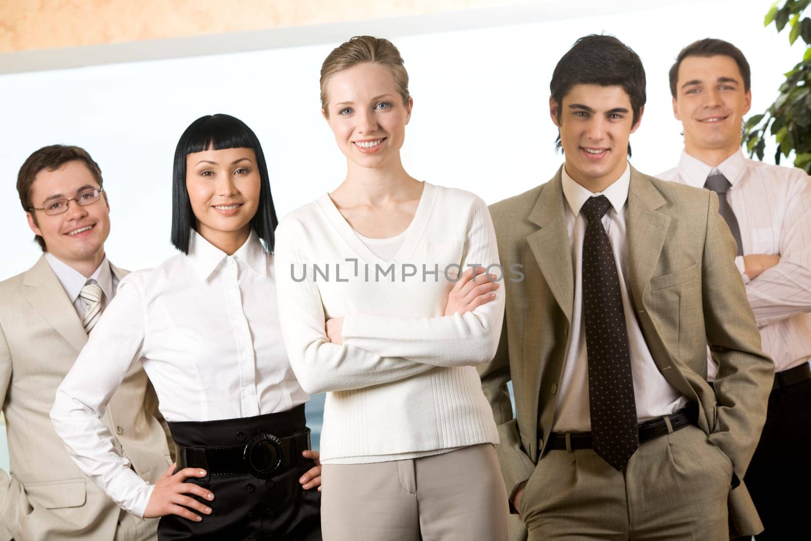 Portrait of friendly business team with pretty female leader in the center