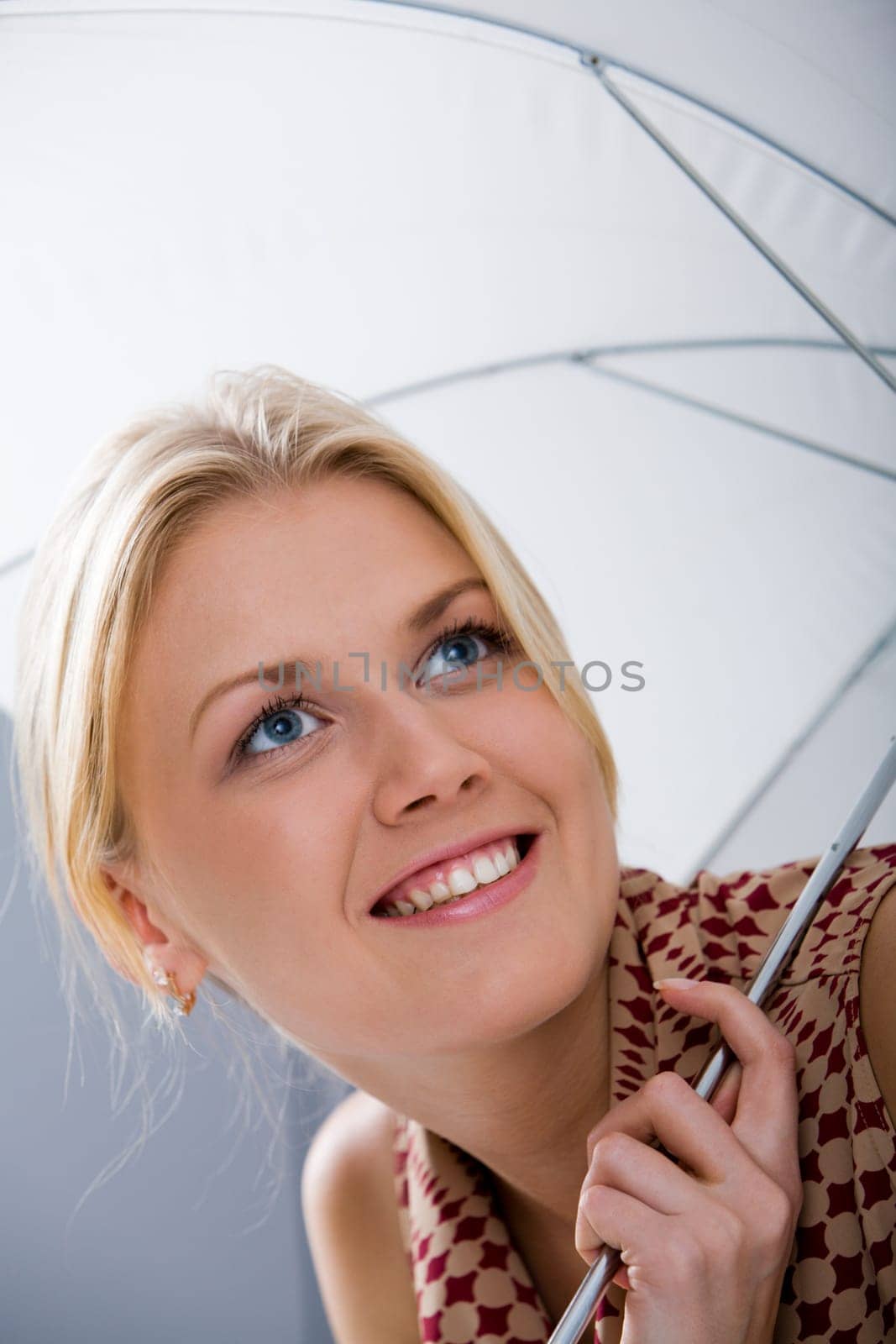 Lovely girl under umbrella smiling
