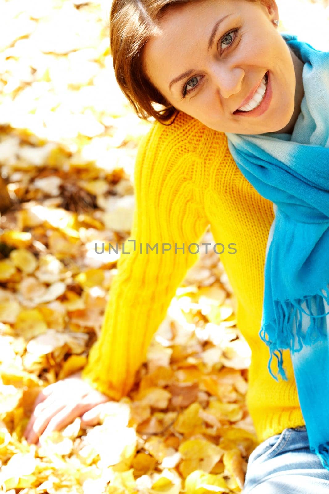 Portrait of joyful woman sitting on foliage