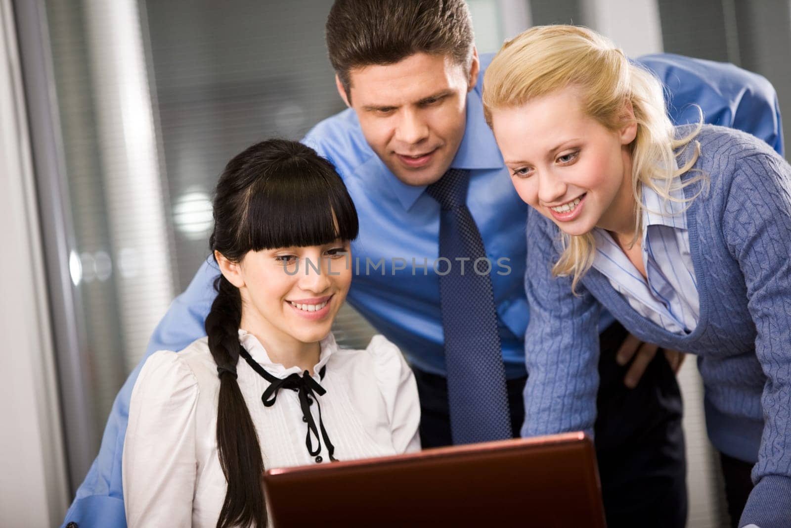 Group of confident employees looking at monitor while planning work