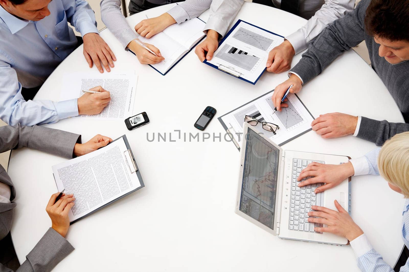 Image of company of successful partners discussing business plan at meeting