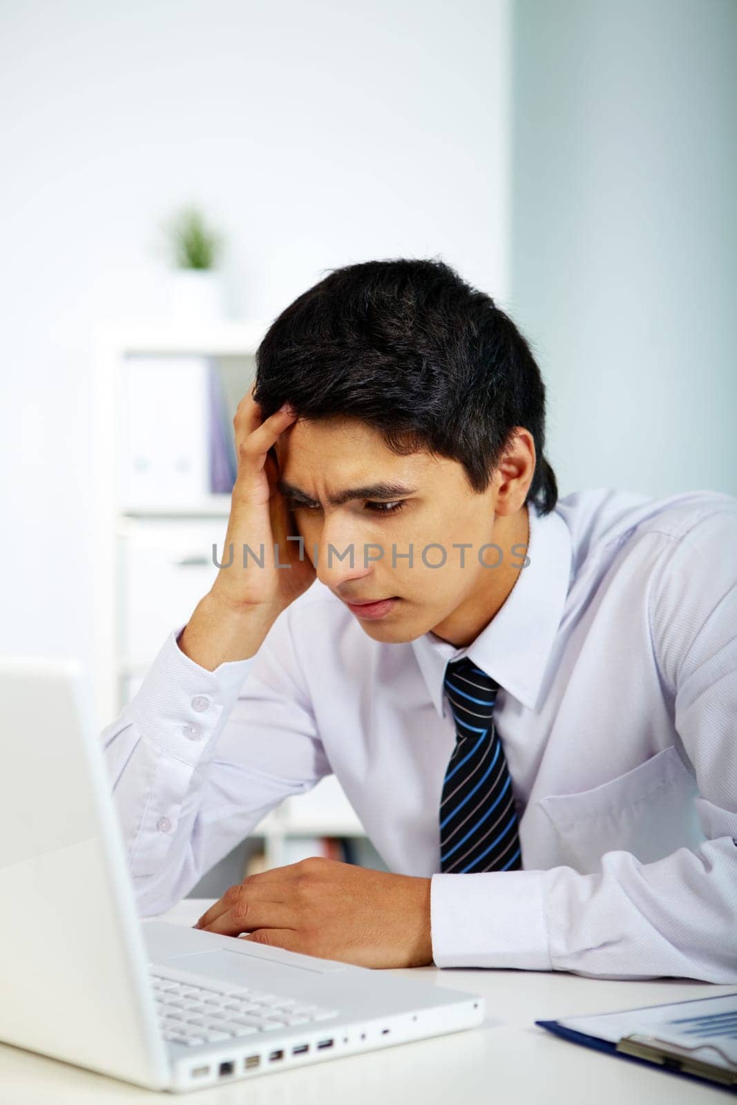Portrait of a businessman looking at laptop screen in office