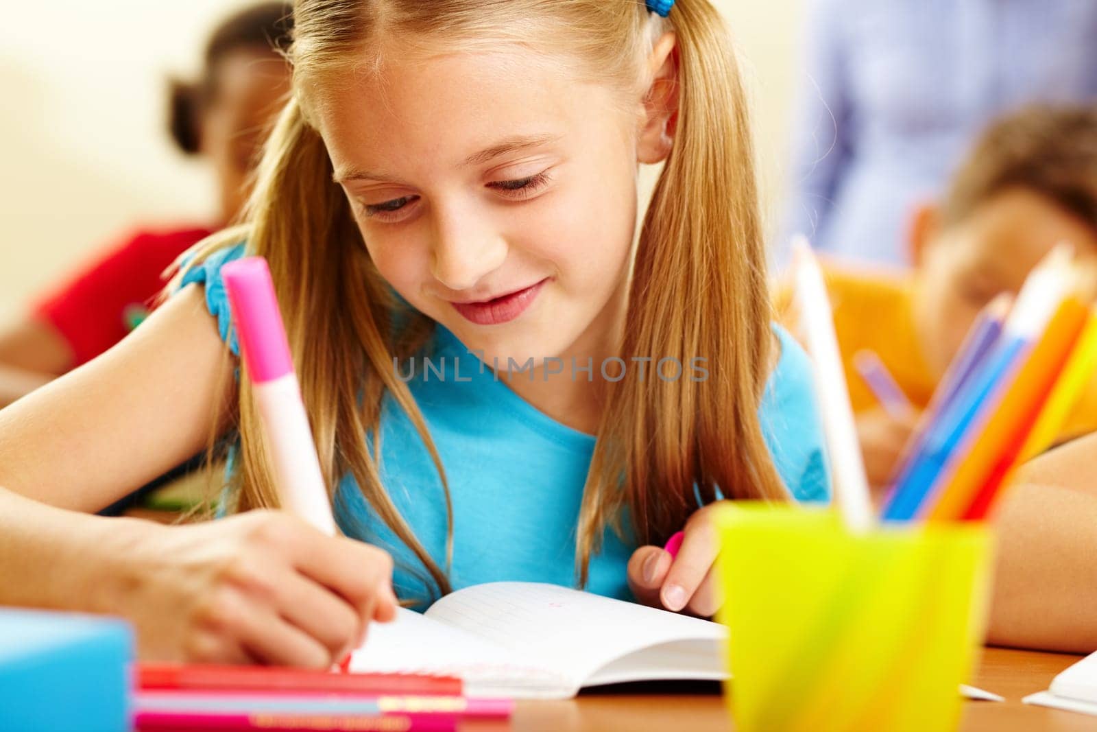 Portrait of lovely girl drawing in copybook at lesson