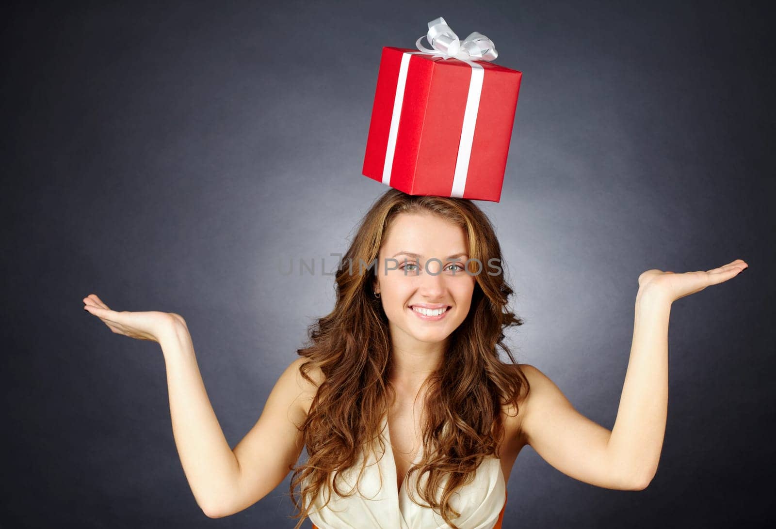 Portrait of a girl with a giftbox balancing on her head