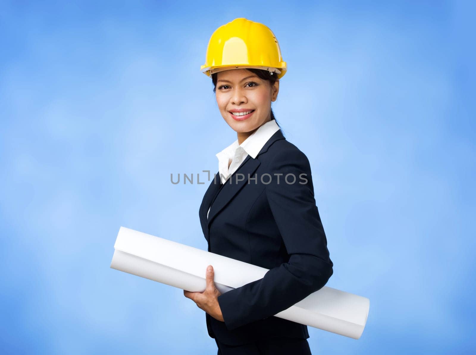 Portrait of confident female worker in helmet holding paper