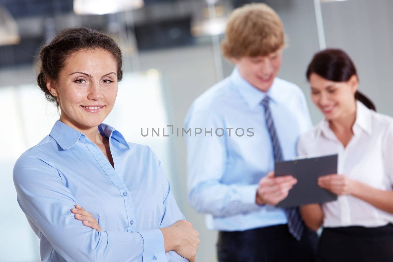 Portrait of friendly specialist looking at camera on the background of colleagues