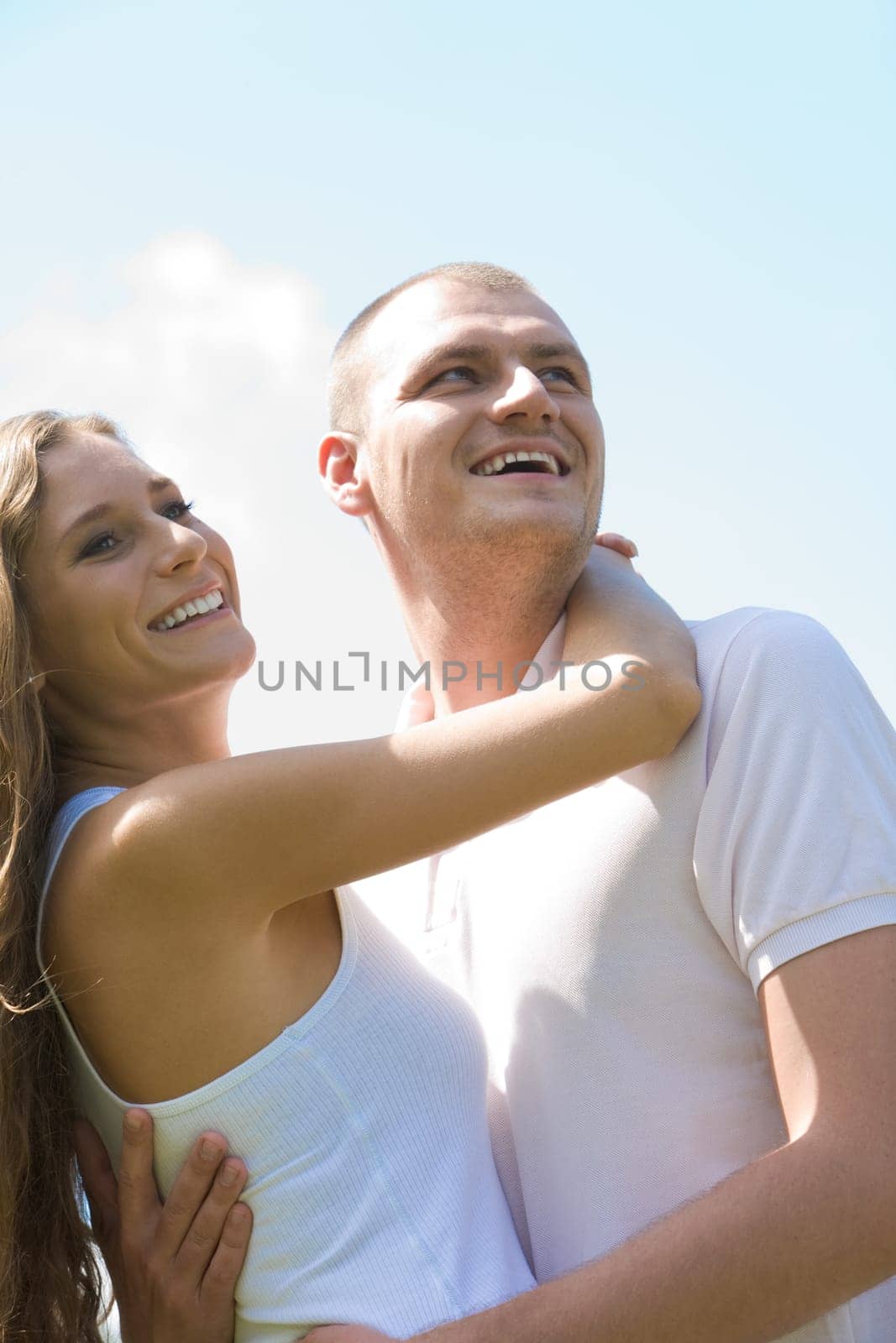 Portrait of happy couple laughing and looking aside while embracing each other