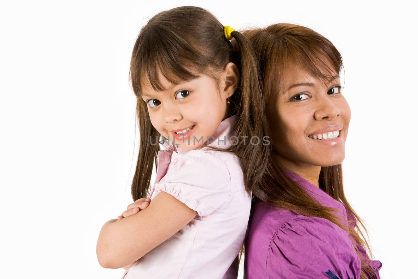 Happy child and her mother looking at camera with smiles on white background