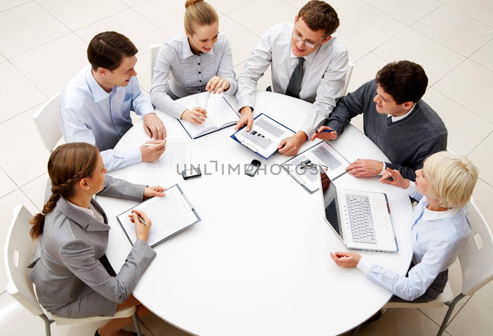 Image of company of successful partners discussing business plan at meeting