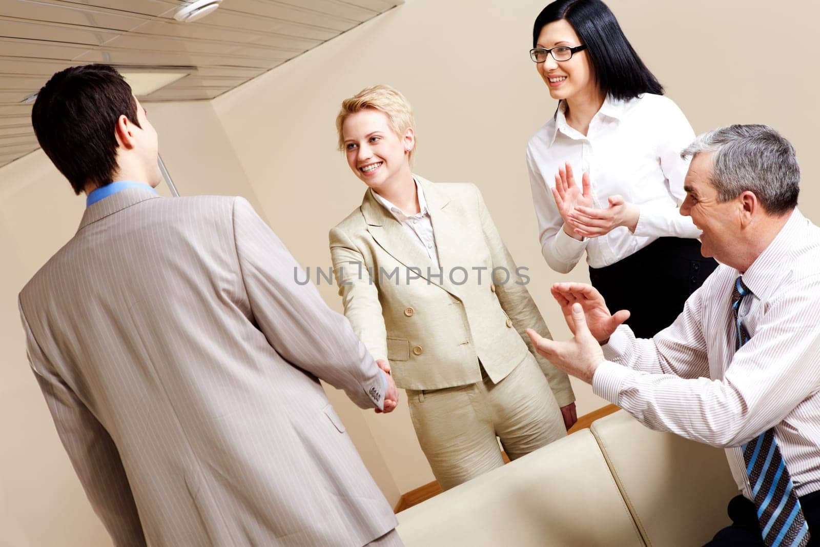 Photo of successful business partners handshaking after striking great deal with applauding people near by