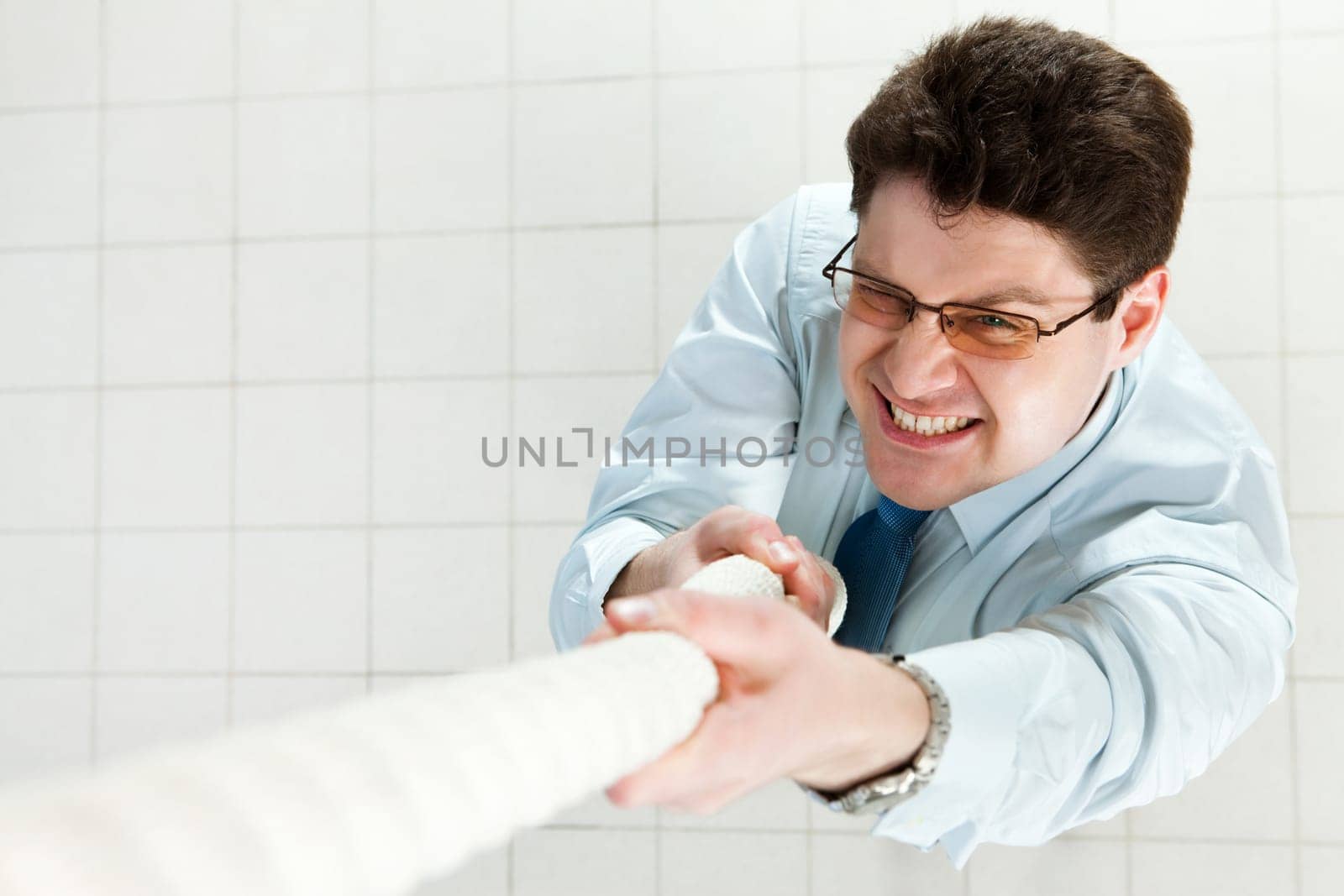 Image of businessman trying to climbing up the rope