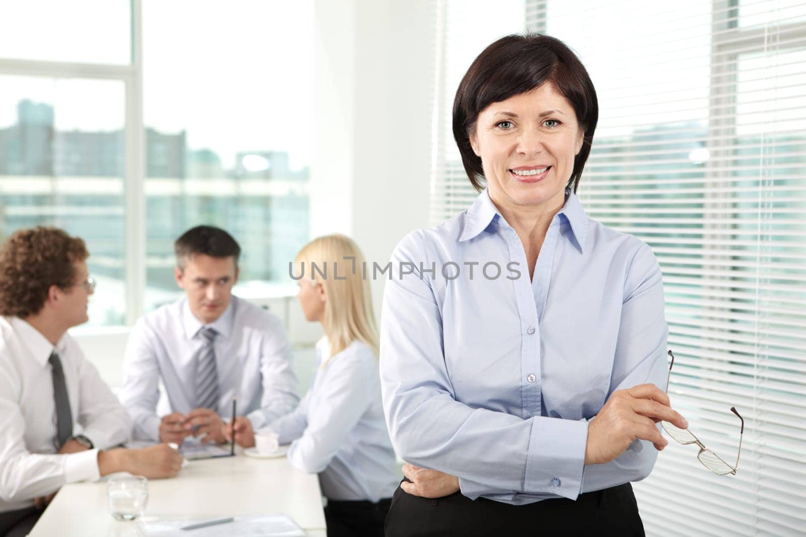 Mature businesswoman looking at camera in working environment