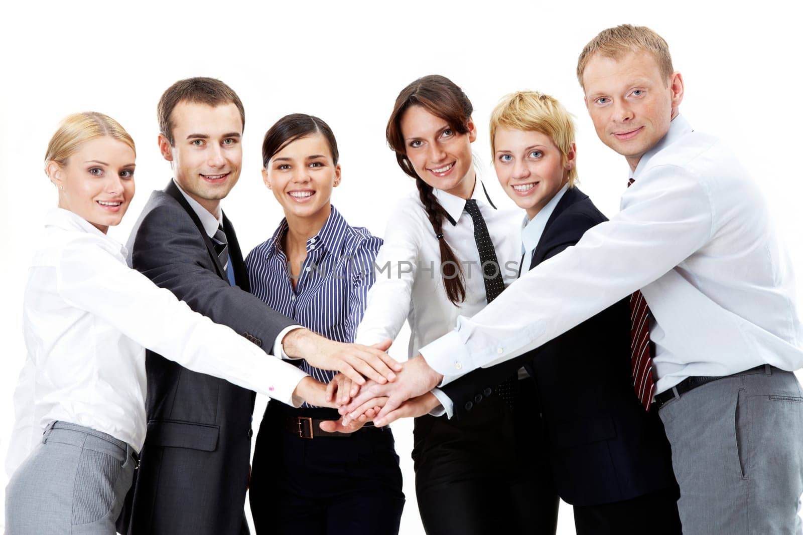 Portrait of friendly business team keeping their hands on top of each other and looking at camera