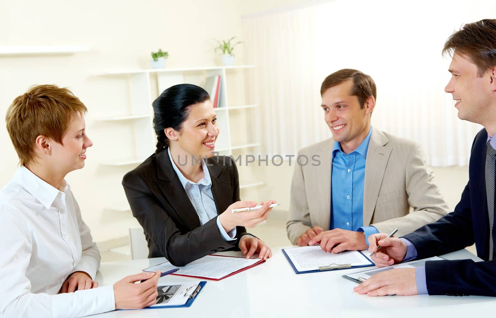 Portrait of businesswoman explaining work to colleagues in the boardroom