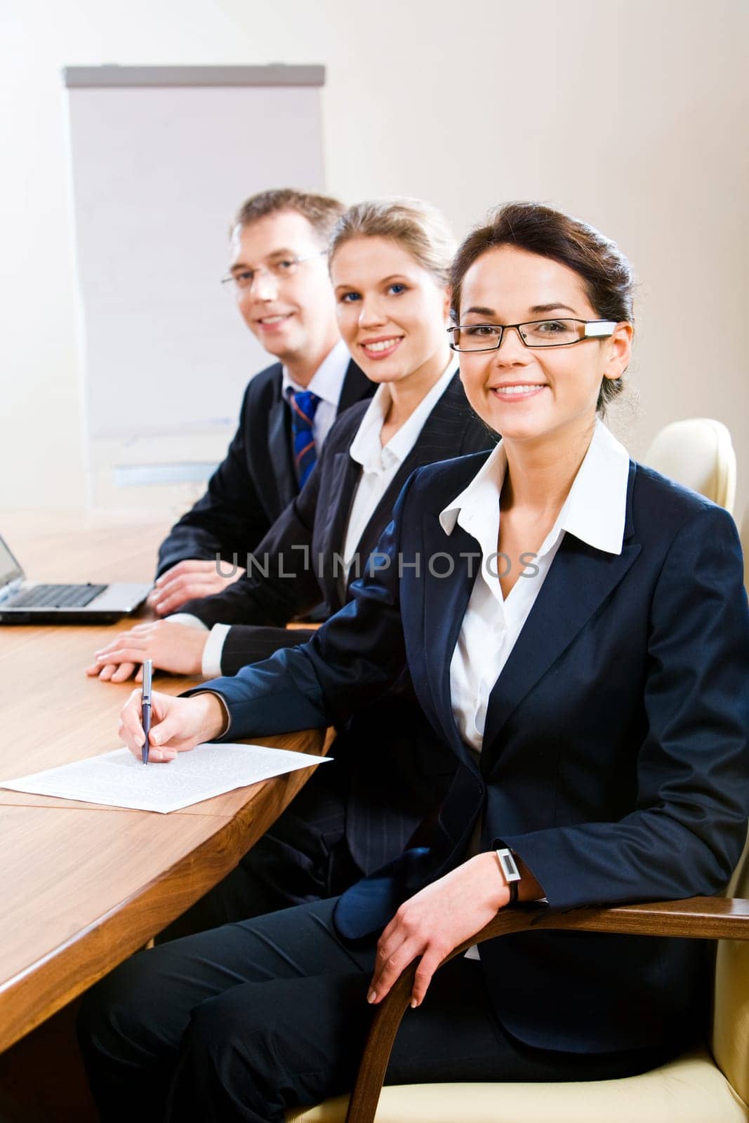 Row of confident white collar workers sitting at the table