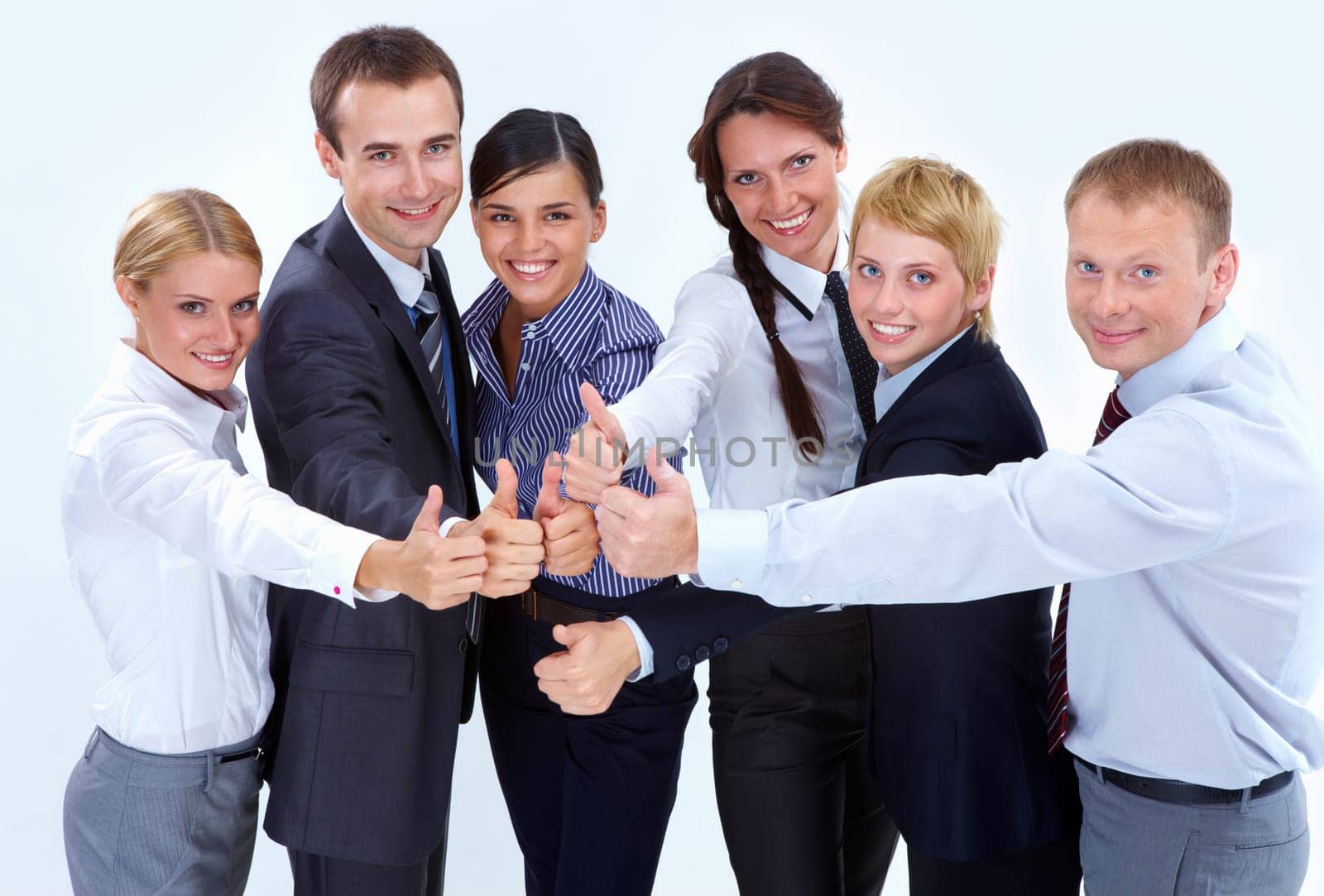 Portrait of friendly business team showing thumbs up and looking at camera