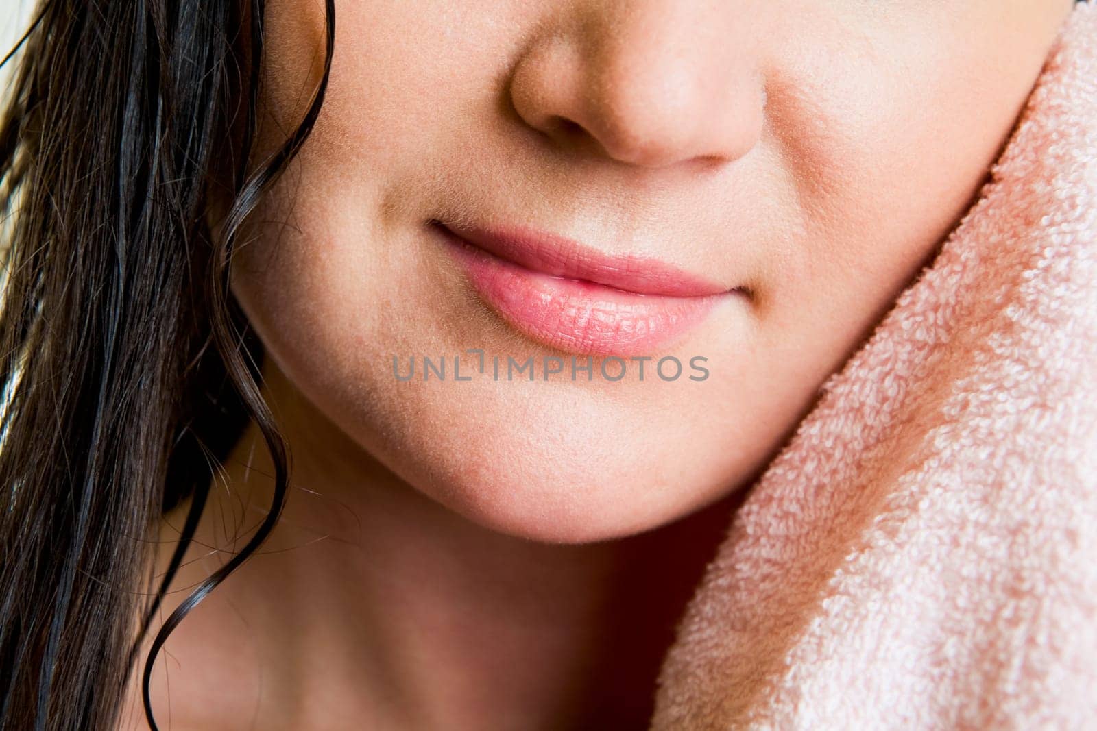 Lower part of female face drying herself with soft towel