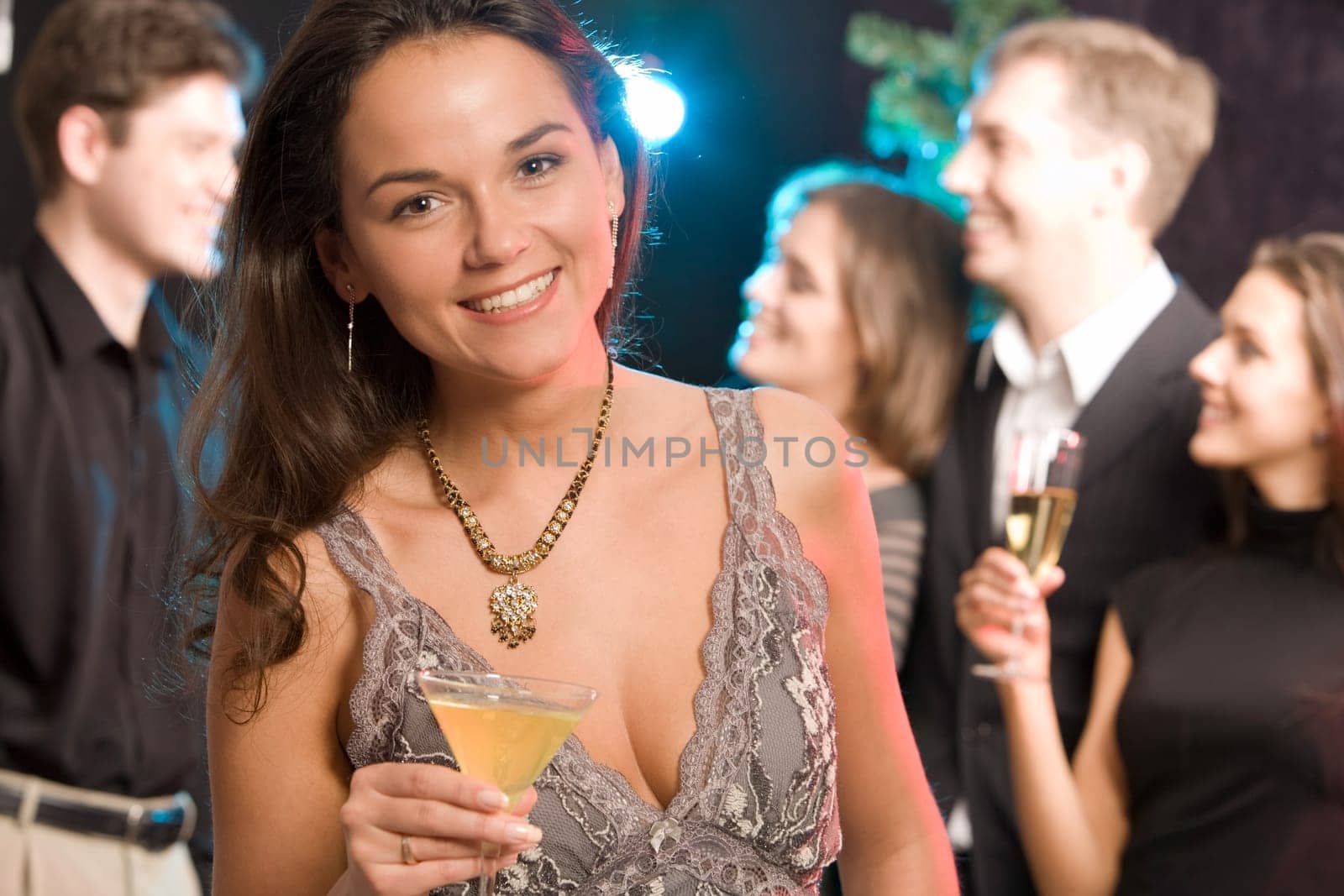 Portrait of charming woman holding her cocktail on the background of people