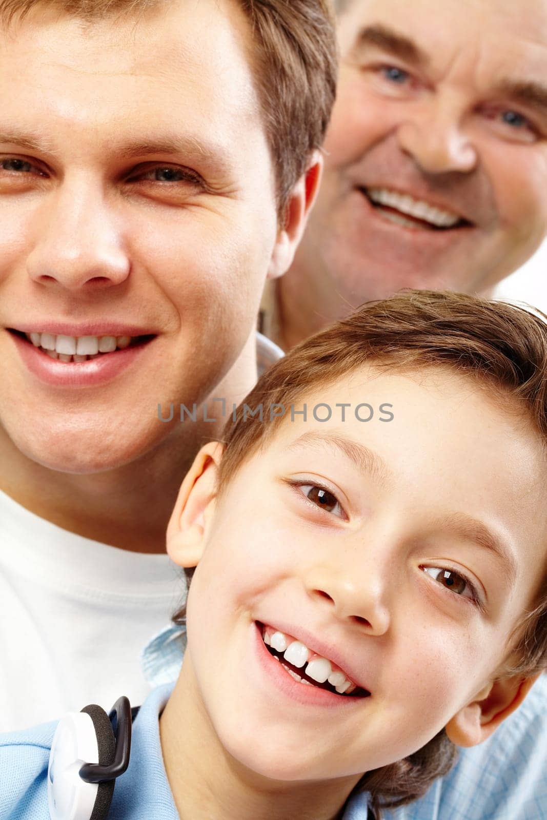 Close-up of a boys face looking at camera among his father and grandfather