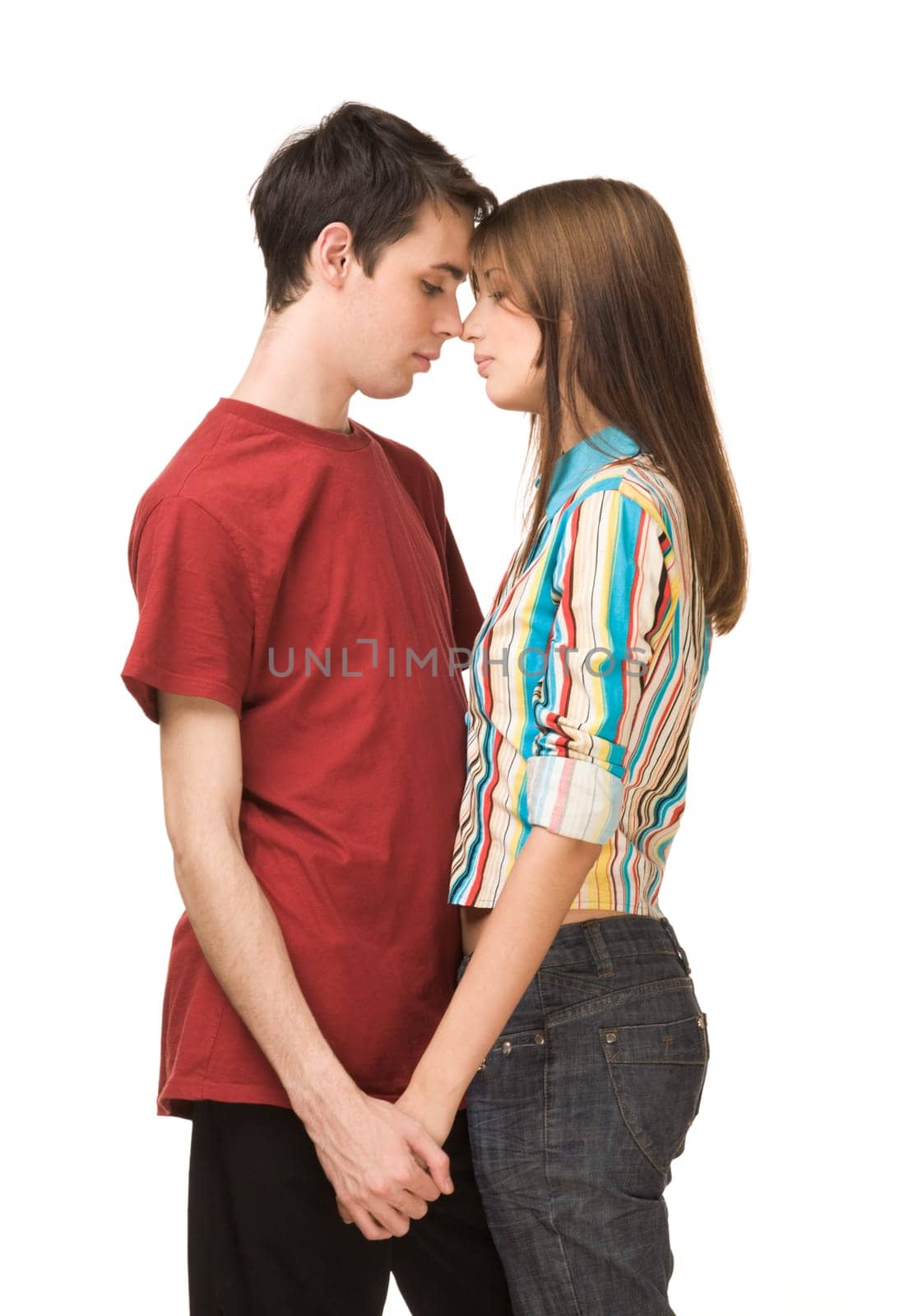Portrait of amorous dates standing face to face and holding each other by hand