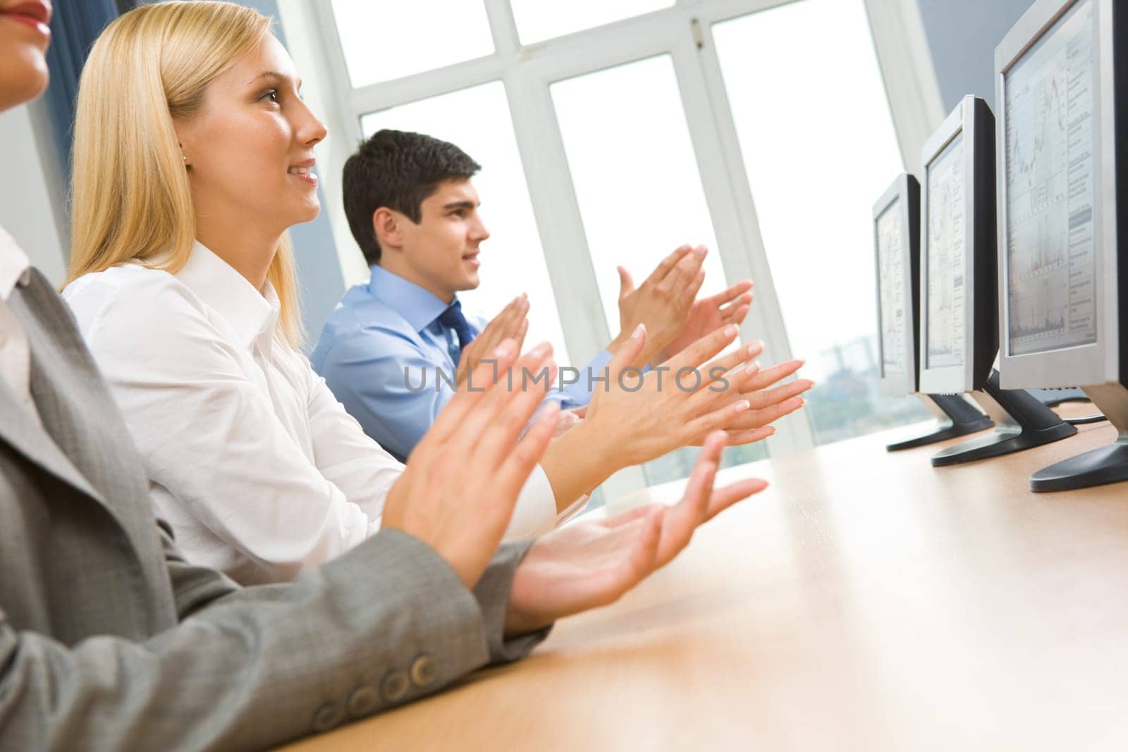 Row of happy business partners applauding at conference