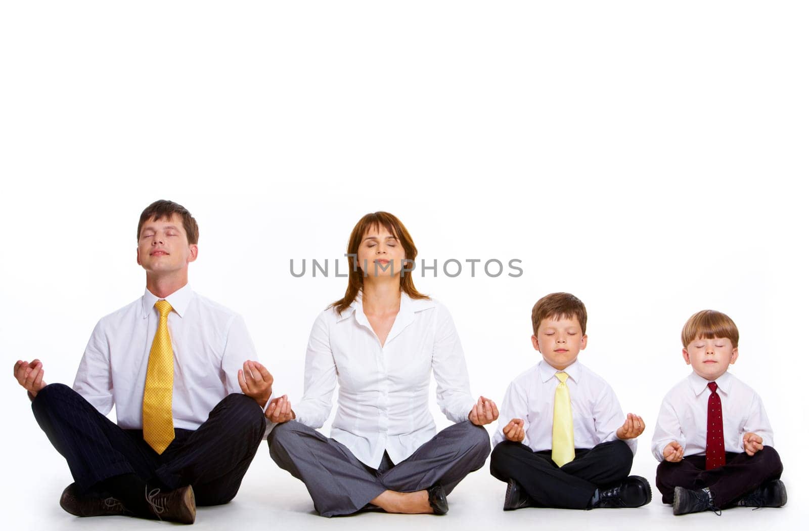 Photo of friendly family sitting in pose of lotus in a row and meditating over white background