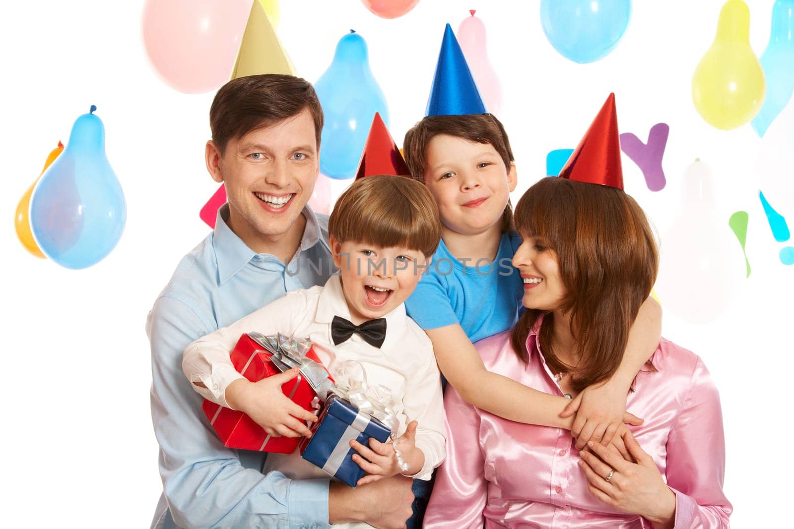 Portrait of happy boys and their parents embracing each other and laughing