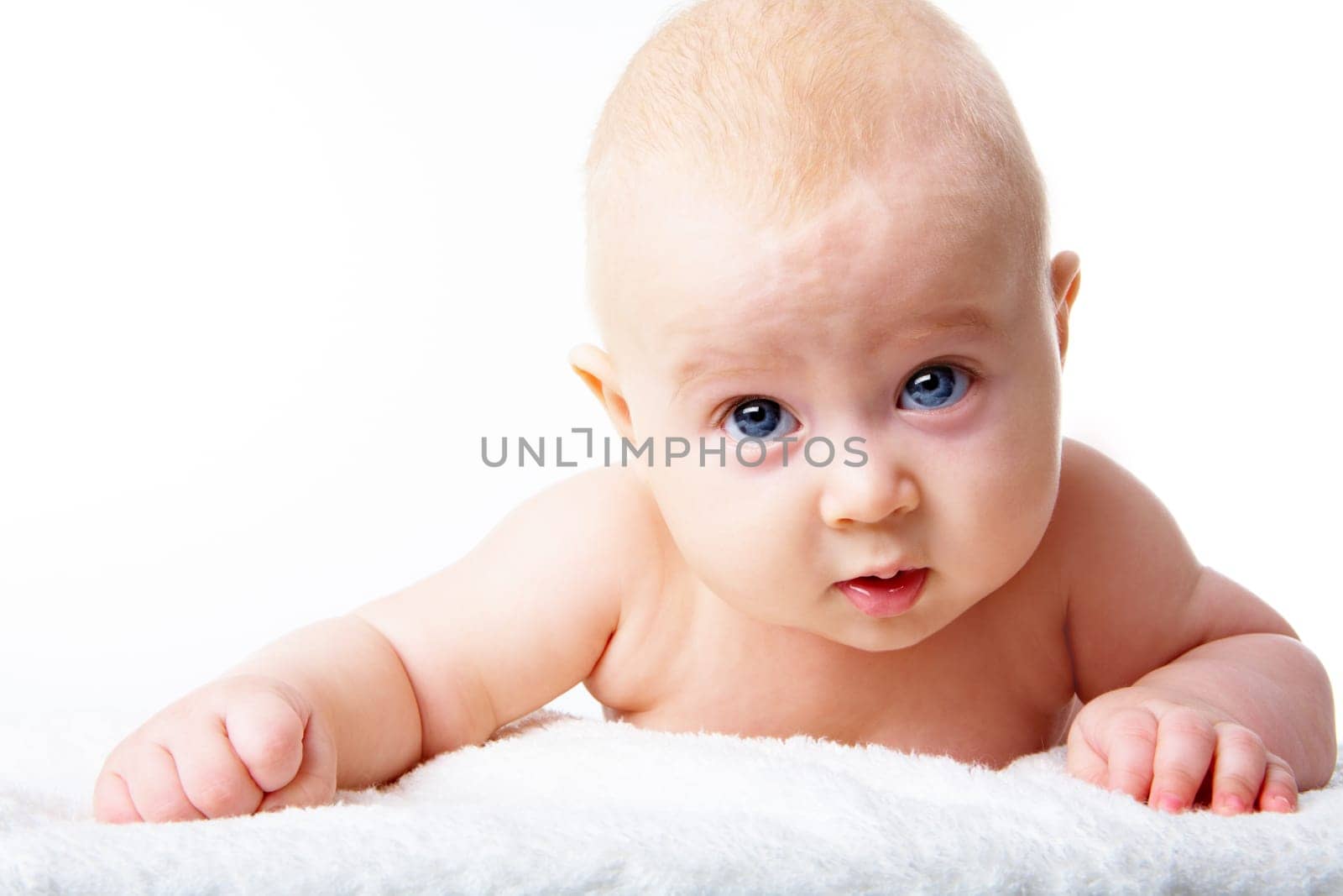 Photo of adorable infant crawling over fluffy rug