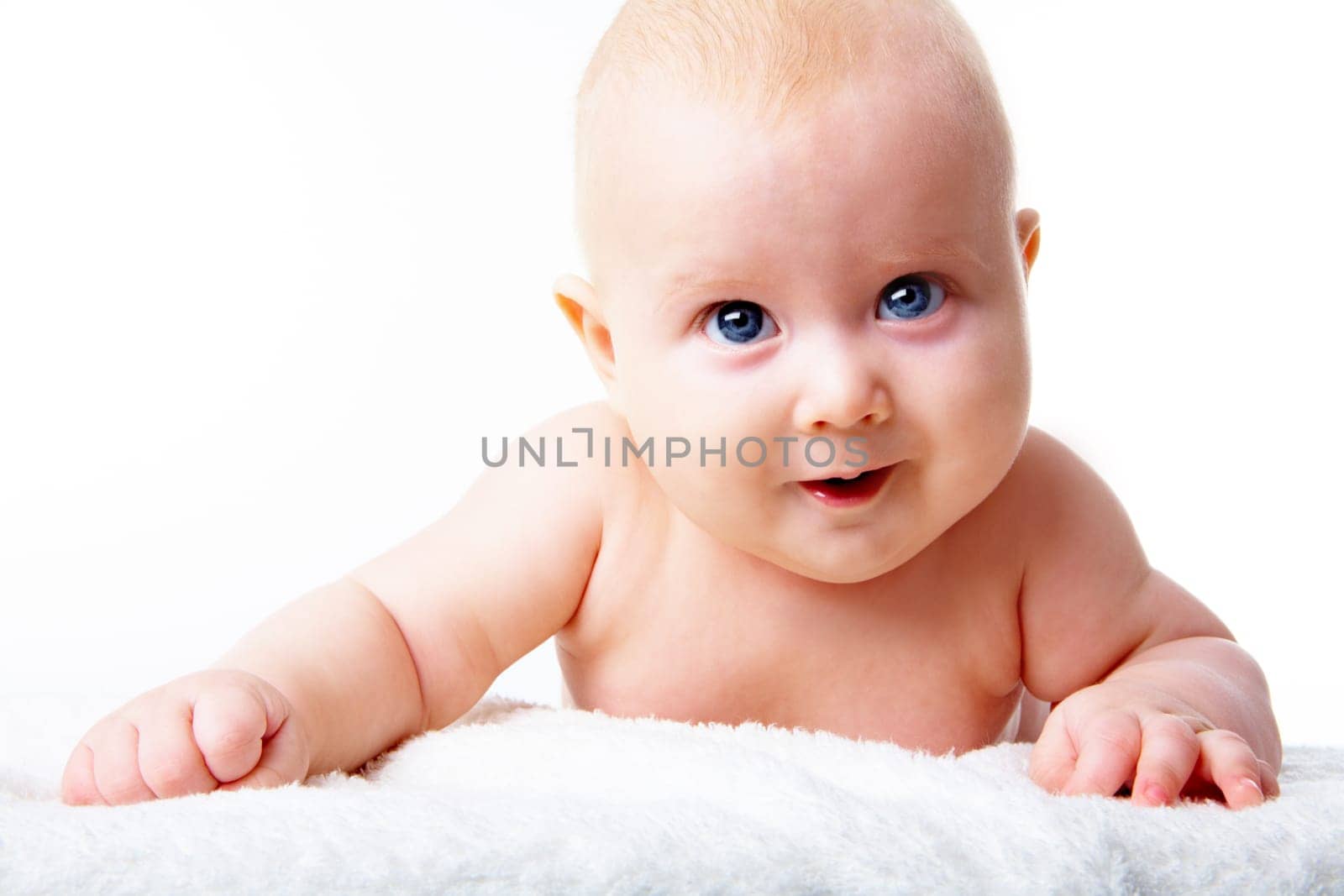 Portrait of happy infant crawling over fluffy rug on a white background
