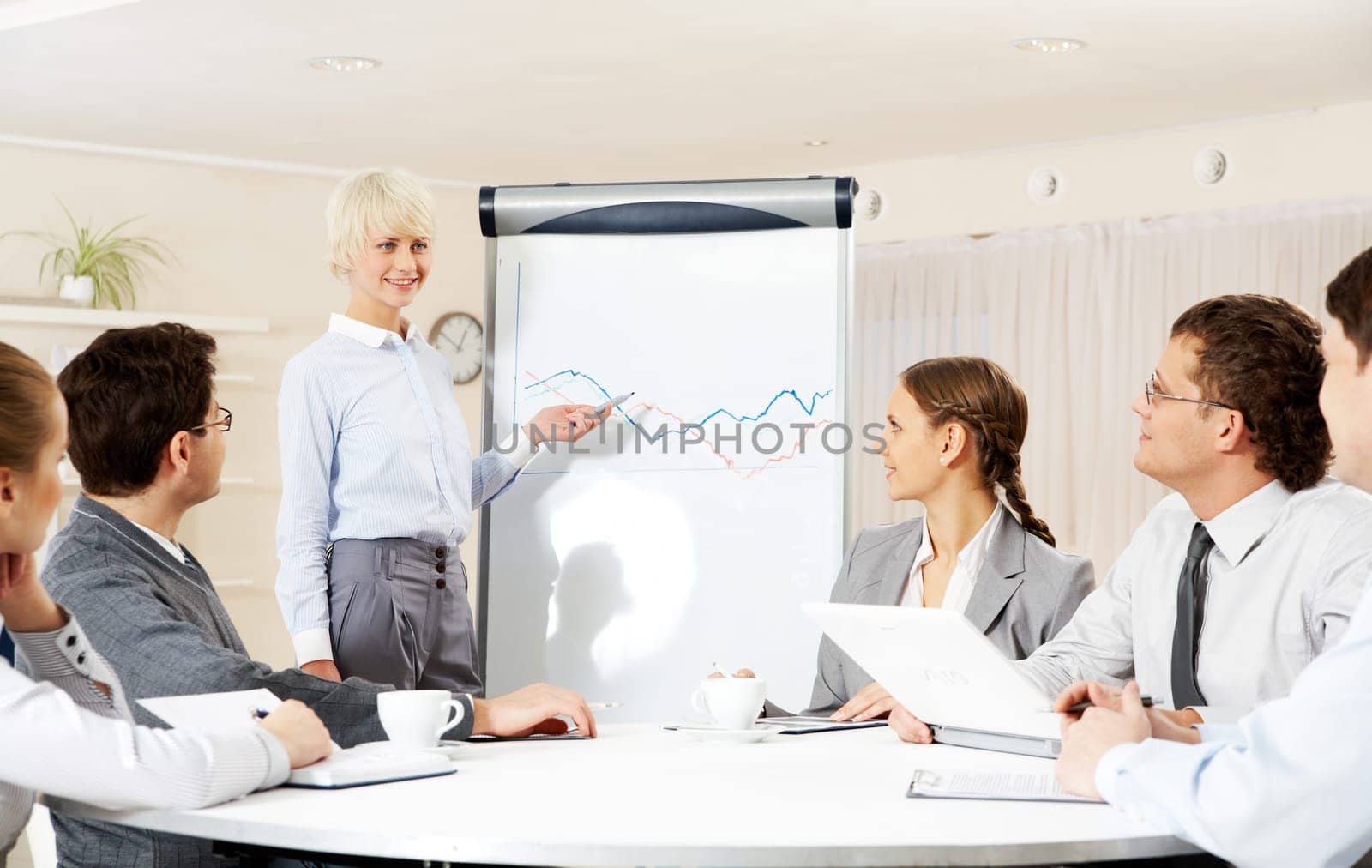 Photo of successful businesswoman reading lecture to colleagues at presentation of new project