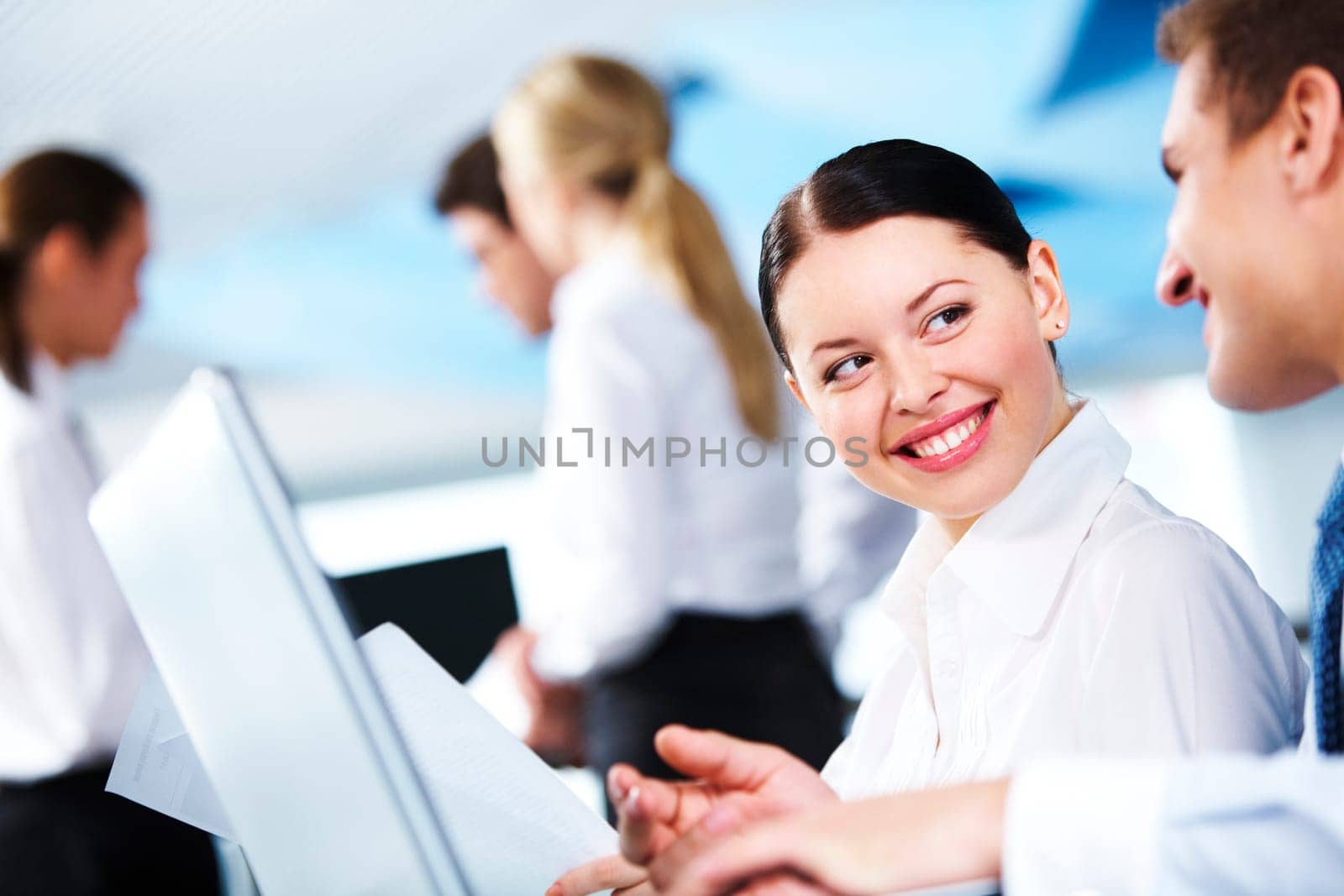 Portrait of executive partners looking at each other on background of their colleagues