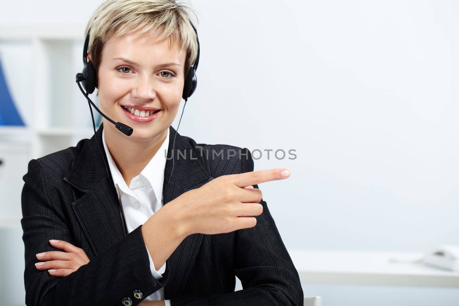 Friendly receptionist with headset showing direction to a visitor