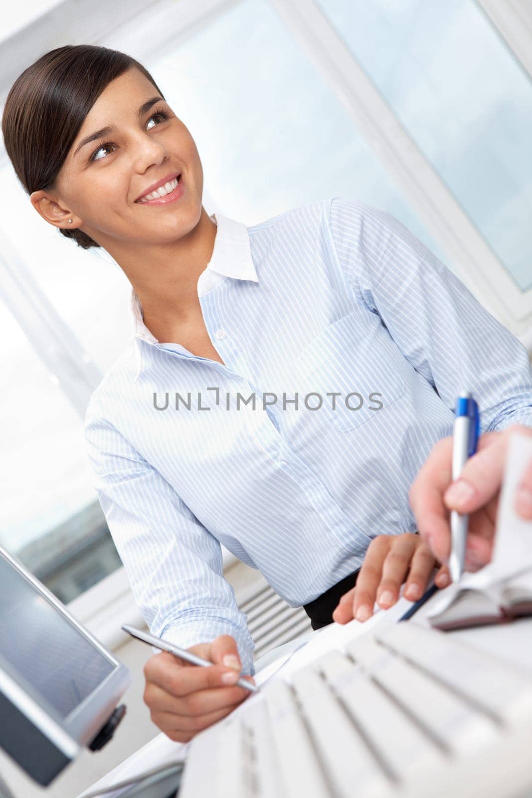 Portrait of working young secretary looking away and smiling