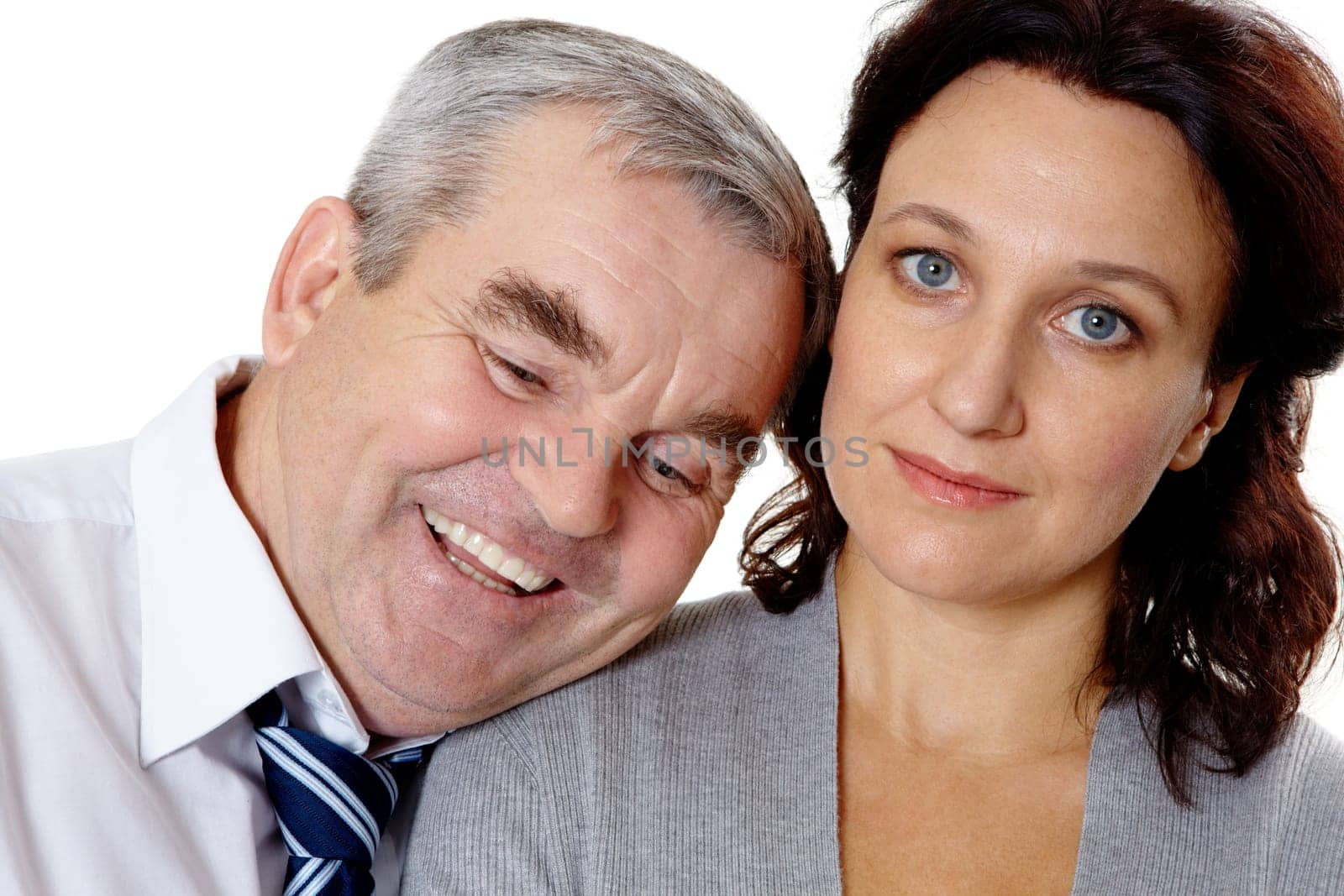 Portrait of middle aged woman looking at camera with happy man laughing near by