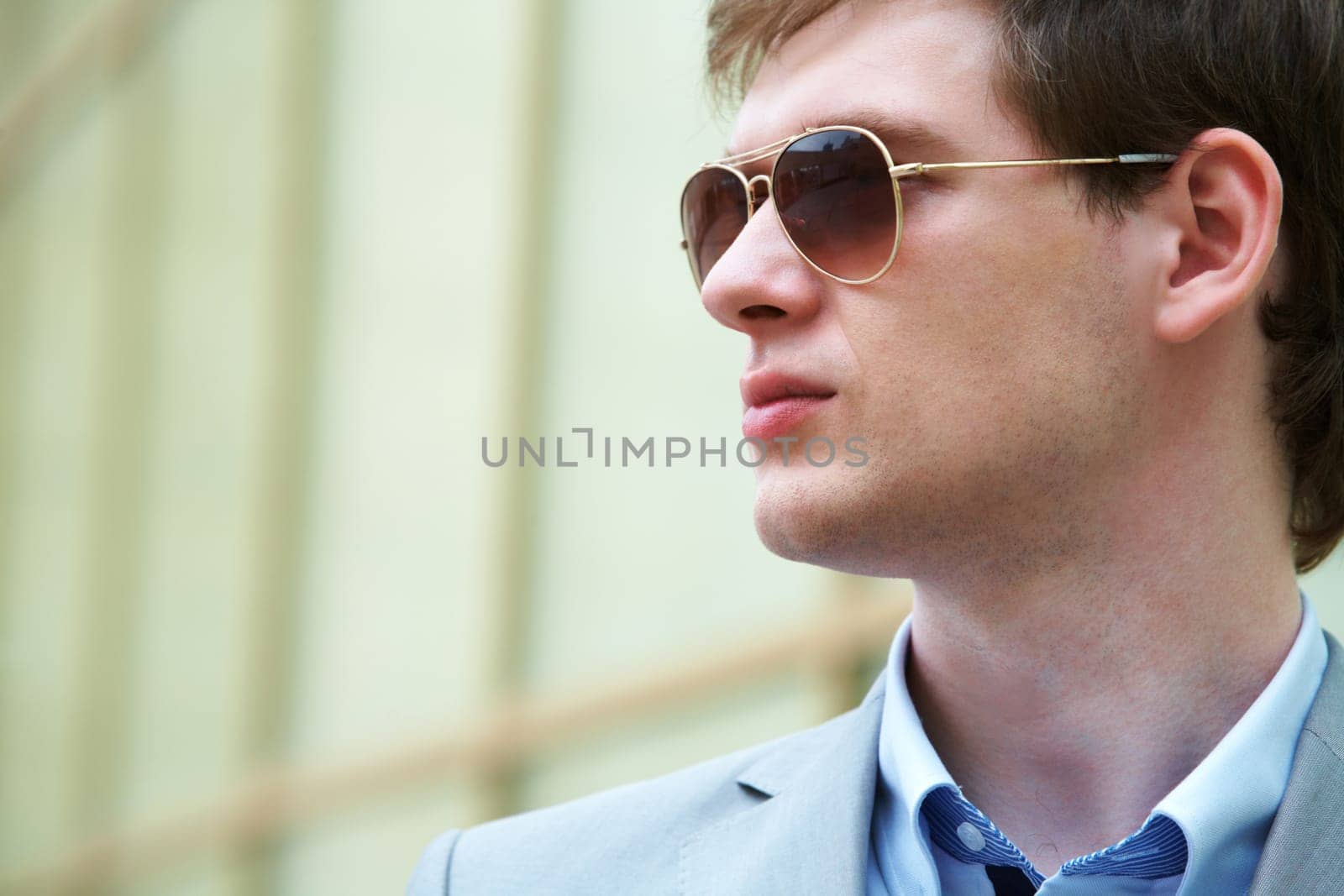 Handsome businessman looking through sunglasses outside