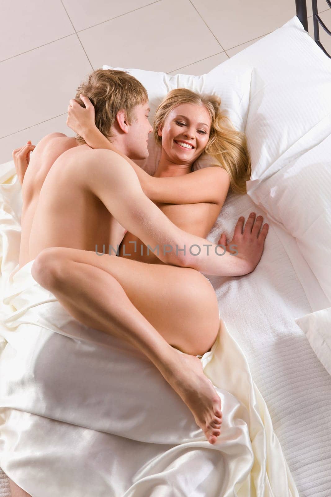 Photo of happy husband and wife enjoying themselves in bed