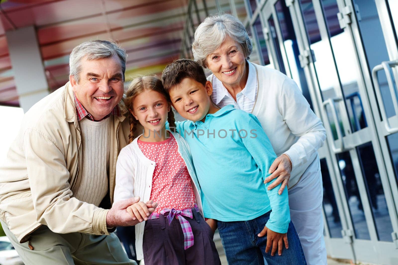 Portrait of happy grandparents and grandchildren by the mall