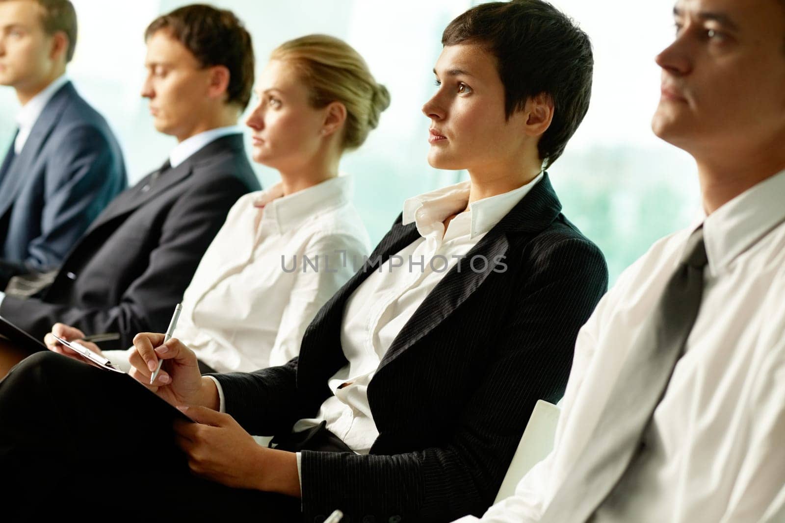 Business people sitting in a row at seminar
