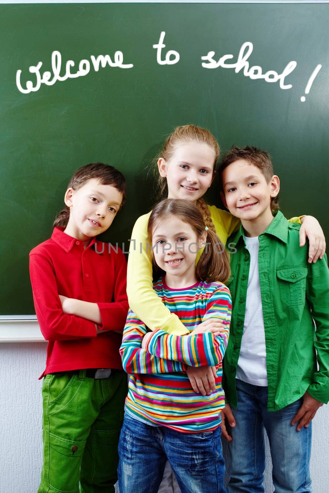 Group of  happy classmates together by whiteboard with text welcome to school