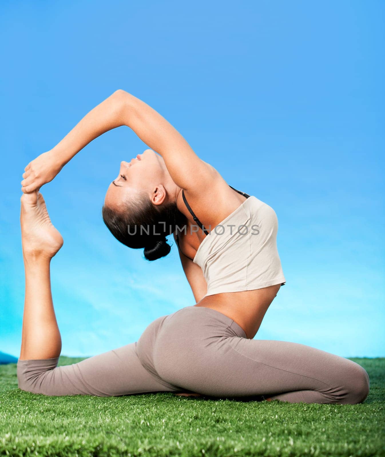 Portrait of slim woman doing stretching exercise on grass