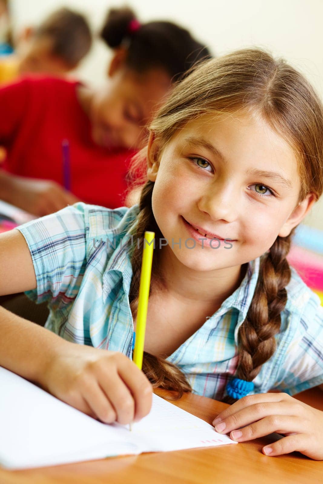 Portrait of lovely girl drawing in copybook at lesson